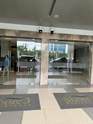 a person walking in an airport lobby with glass doors at Gateway Mall of Asia Near Airport in Manila