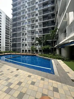 a swimming pool in front of a large apartment building at Gateway Mall of Asia Near Airport in Manila