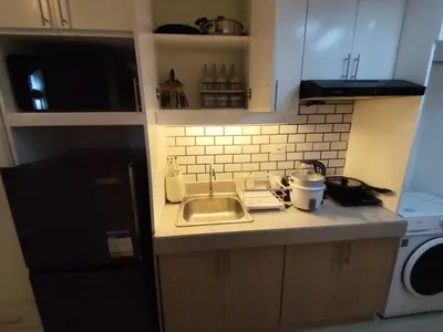 a small kitchen with a sink and a refrigerator at Naomi's Green Haven in Dasmariñas