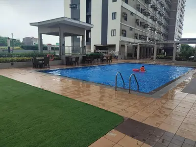 a person in a swimming pool in a building at Naomi's Green Haven in Dasmariñas