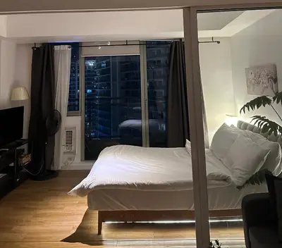 a bedroom with a bed and a view of a city at Azure staycation in Manila