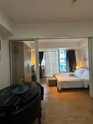 a hotel room with a bed and a dining table at Azure staycation in Manila
