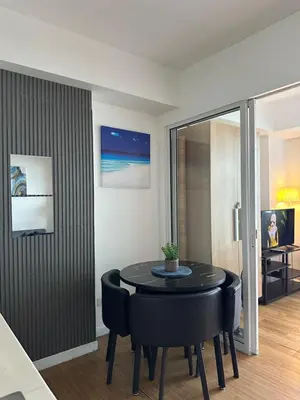 a dining room with a black table and chairs at Azure staycation in Manila