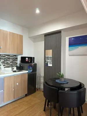 a kitchen and dining room with a table and chairs at Azure staycation in Manila