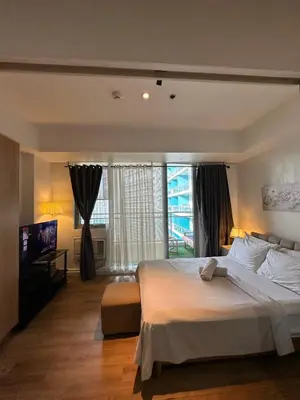 a bedroom with a large bed and a large window at Azure staycation in Manila