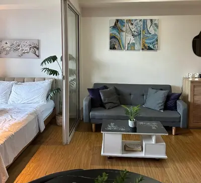 a living room with a bed and a couch at Azure staycation in Manila