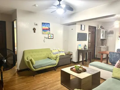 a living room with a couch and a table at Comfortable 1BR Pasig Apartment in Manila