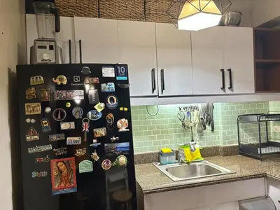 a refrigerator in a kitchen with magnets on it at Comfortable 1BR Pasig Apartment in Manila