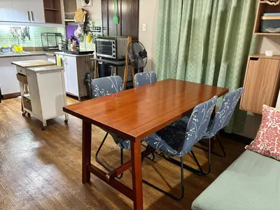 a kitchen with a wooden table and blue chairs at Comfortable 1BR Pasig Apartment in Manila