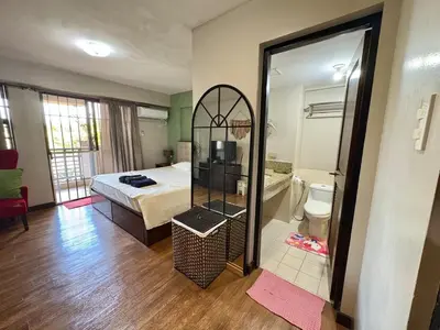 a bedroom with a bed and a large mirror at Comfortable 1BR Pasig Apartment in Manila