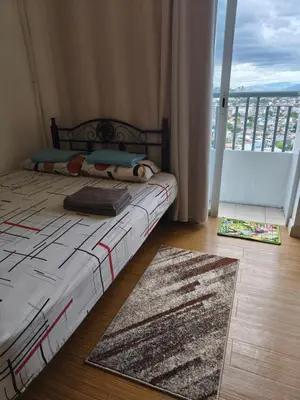 a bedroom with a bed and a large window at Netflix and Chill Ephra's Place in Manila
