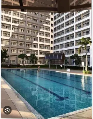 a swimming pool in front of a large building at Netflix and Chill Ephra's Place in Manila
