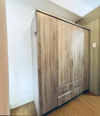a large closet with wooden doors in a room at Netflix and Chill Ephra's Place in Manila