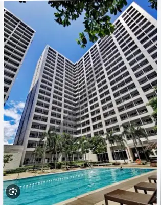 a large building with a swimming pool in front of it at Netflix and Chill Ephra's Place in Manila