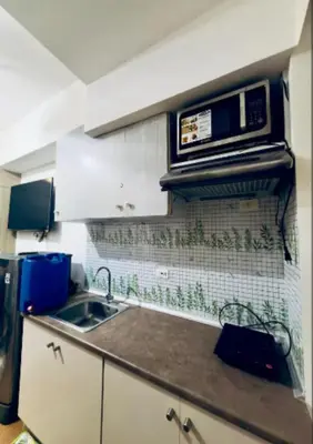 a kitchen with a sink and a microwave at Netflix and Chill Ephra's Place in Manila