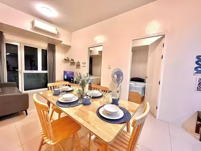 a dining room with a table with chairs and a couch at Staycation Casa Filipina in Manila