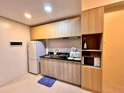 a small kitchen with a refrigerator and a microwave at Staycation Casa Filipina in Manila