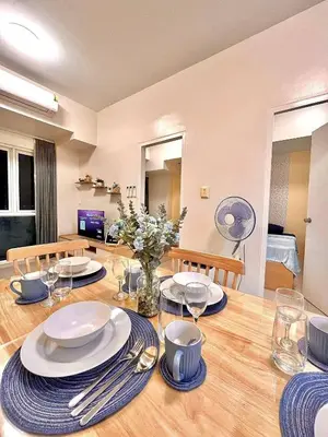 a dining room table with plates and silverware on it at Staycation Casa Filipina in Manila