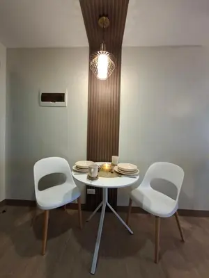 a table with two white chairs and a table and a light at THE Faithful Nest in General Trias
