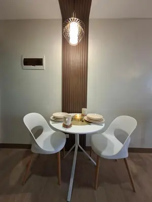 a white table with chairs and a light fixture at THE Faithful Nest in General Trias