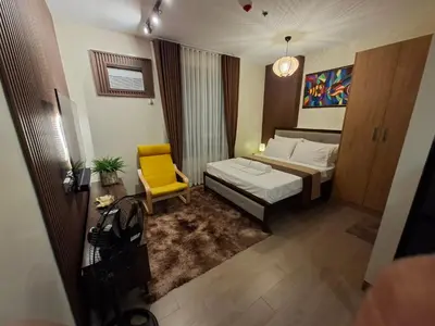 a hotel room with a bed and a yellow chair at THE Faithful Nest in General Trias