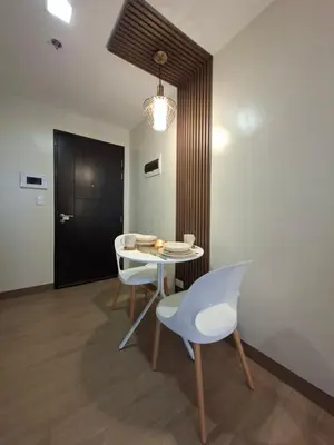 a dining room with a table and chairs and a black door at THE Faithful Nest in General Trias