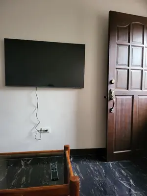 a room with a flat screen tv and a door at Kame House fully furnished 2BR in Bacoor
