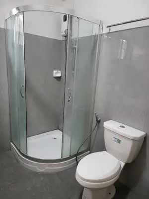 a bathroom with a toilet and a glass shower at Kame House fully furnished 2BR in Bacoor