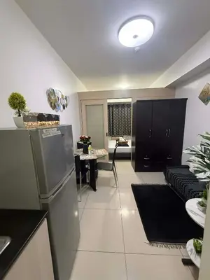 a kitchen and living room with a couch and a table at Sea Residences StaycationAtMOA in Manila
