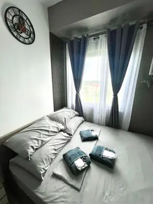 a bed with two pillows and a clock on the wall at SELF CHECK-IN Near La Salle Dasma in Dasmariñas