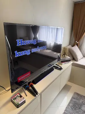 a living room with a large flat screen tv at The Luxe Forbeswood BGC in Manila