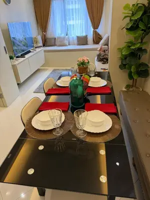 a dining room table with plates and glasses on it at The Luxe Forbeswood BGC in Manila