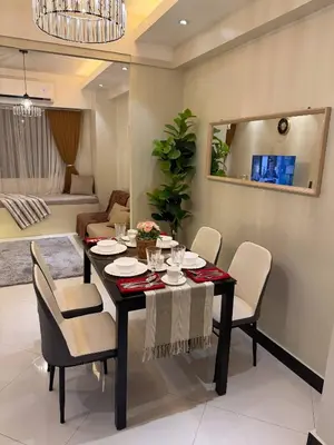 a dining room with a table and chairs at The Luxe Forbeswood BGC in Manila