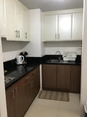 a kitchen with white cabinets and a sink at Sleep and Fly Condotel in Manila