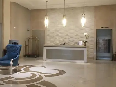 a lobby with a blue chair and a reception desk at Sleep and Fly Condotel in Manila