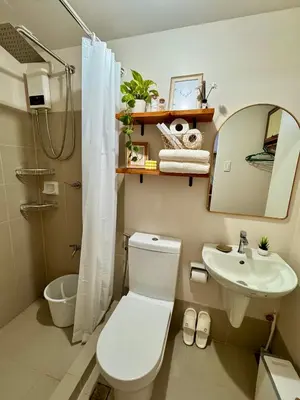 a bathroom with a toilet and a sink and a mirror at A'more Cosy Stay Near Nuvali at Fullerton Suites in Silang