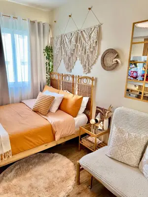 a bedroom with a bed and a mirror and a chair at A'more Cosy Stay Near Nuvali at Fullerton Suites in Silang