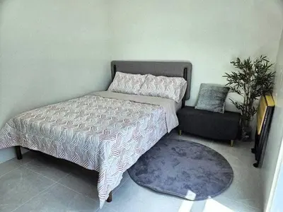 a bedroom with a bed and a chair and a rug at MANILA AIR RESIDENCE 24 floor in Manila