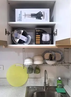 a kitchen counter with a sink and a shelf with dishes at MANILA AIR RESIDENCE 24 floor in Manila