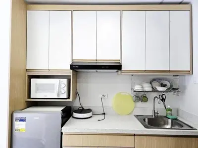 a kitchen with white cabinets and a refrigerator and a balloon at MANILA AIR RESIDENCE 24 floor in Manila