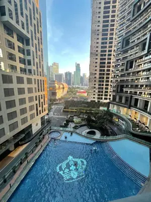 a large swimming pool in a city with tall buildings at Sozy Cozy Knightsbridge Residences 1 in Manila