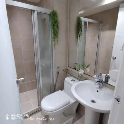 a bathroom with a toilet and a sink and a shower at Sozy Cozy Knightsbridge Residences 1 in Manila