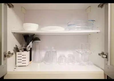 a cabinet filled with lots of glasses and plates at BGC Uptown Condotel in Manila