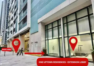 two red signs in front of a building at BGC Uptown Condotel in Manila