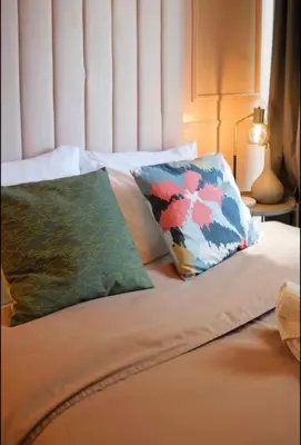 a bed with two pillows on top of it at BGC Uptown Condotel in Manila