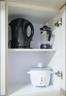 a shelf with a tea pot and a blender at BGC Uptown Condotel in Manila