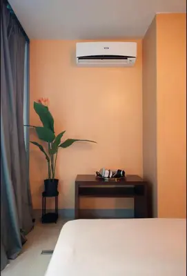 a bedroom with a bed and a table with a plant at BGC Uptown Condotel in Manila