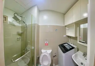 a bathroom with a shower and a toilet and a sink at Cozy condo unit in Manila
