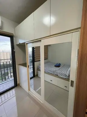 a small bedroom with a bed in a room with a window at Cozy condo unit in Manila