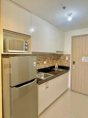 a kitchen with a stainless steel refrigerator and a sink at Cozy condo unit in Manila